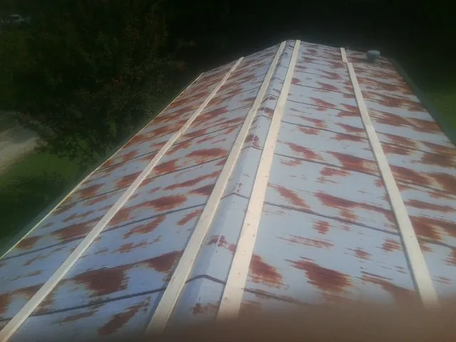 Rusted metal roof panels with new wood purlins before replacement — Storm Damage Roof Repair in Walton by Roofing Brothers