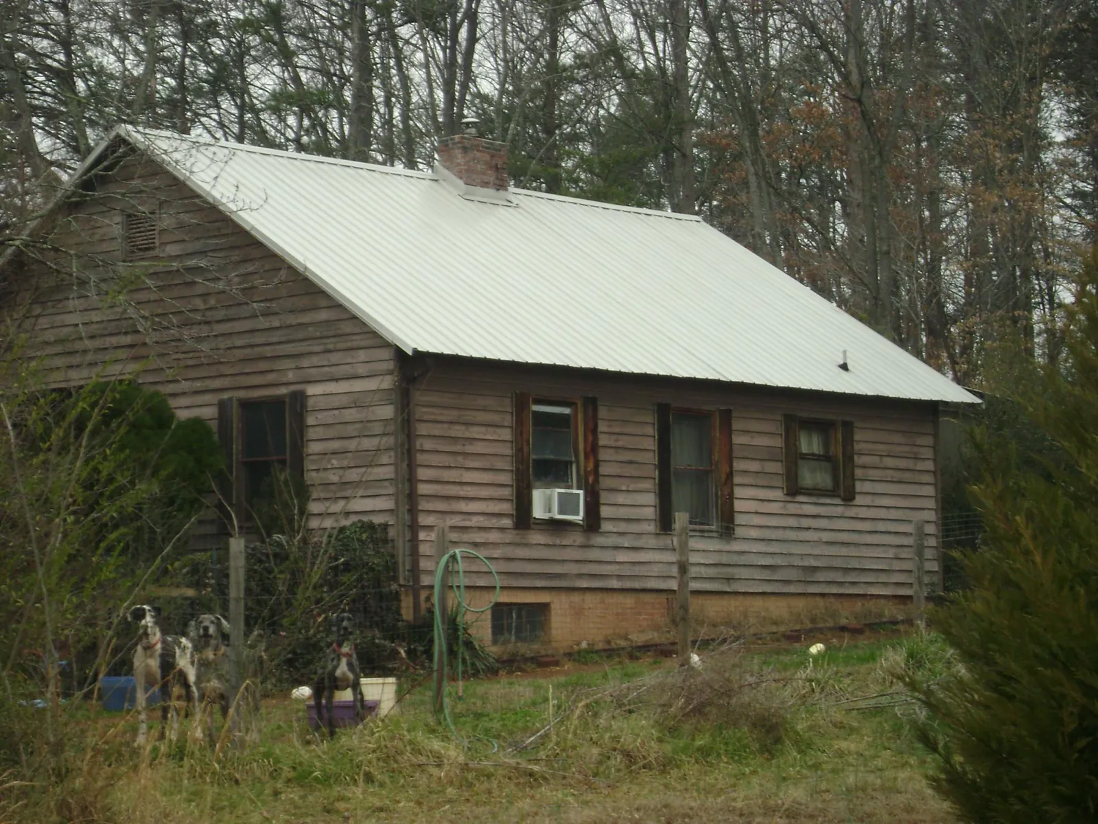 White metal roof on an old wood sided farmhouse, from a Metal Roof Installation job in Walton